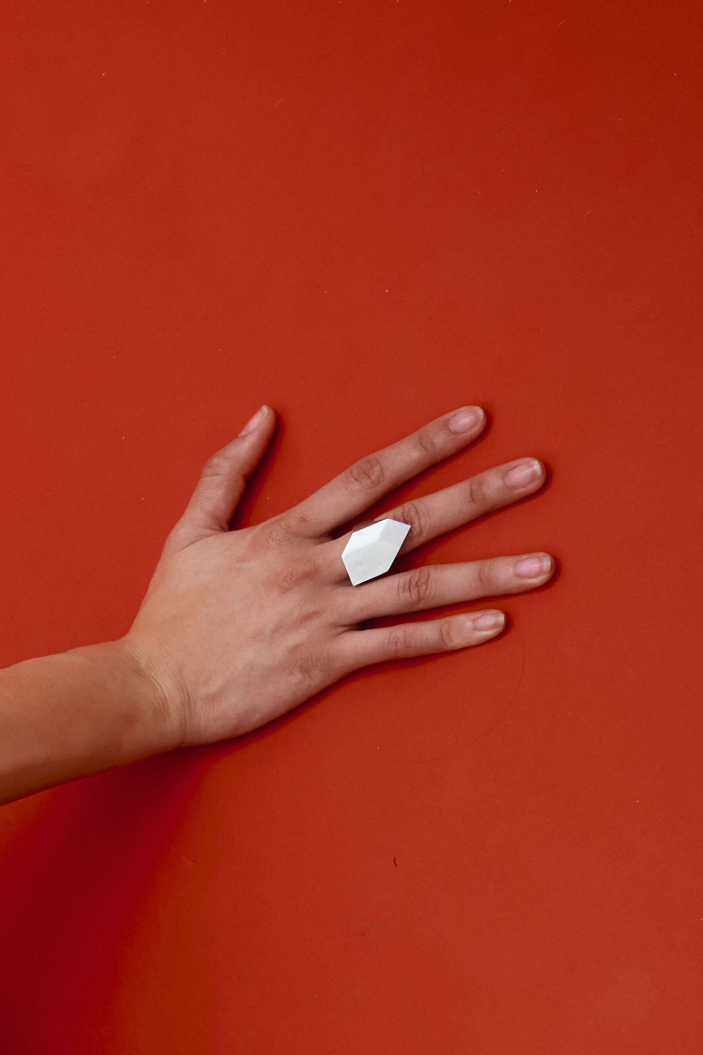 Close-up of minimalist sterling silver signet ring with balanced architectural proportions.