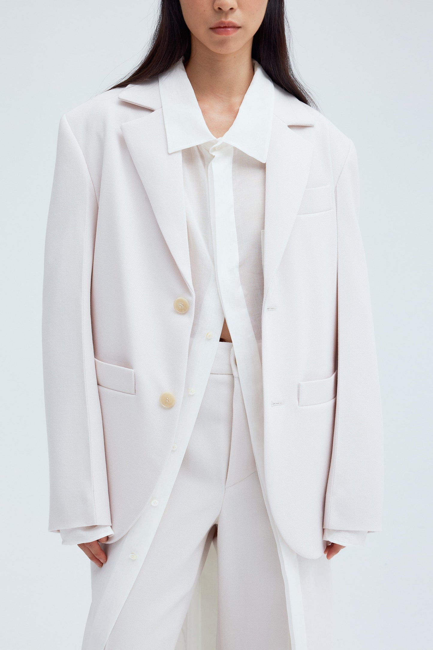 Cara wearing unisex wool blazer in ecru on white background