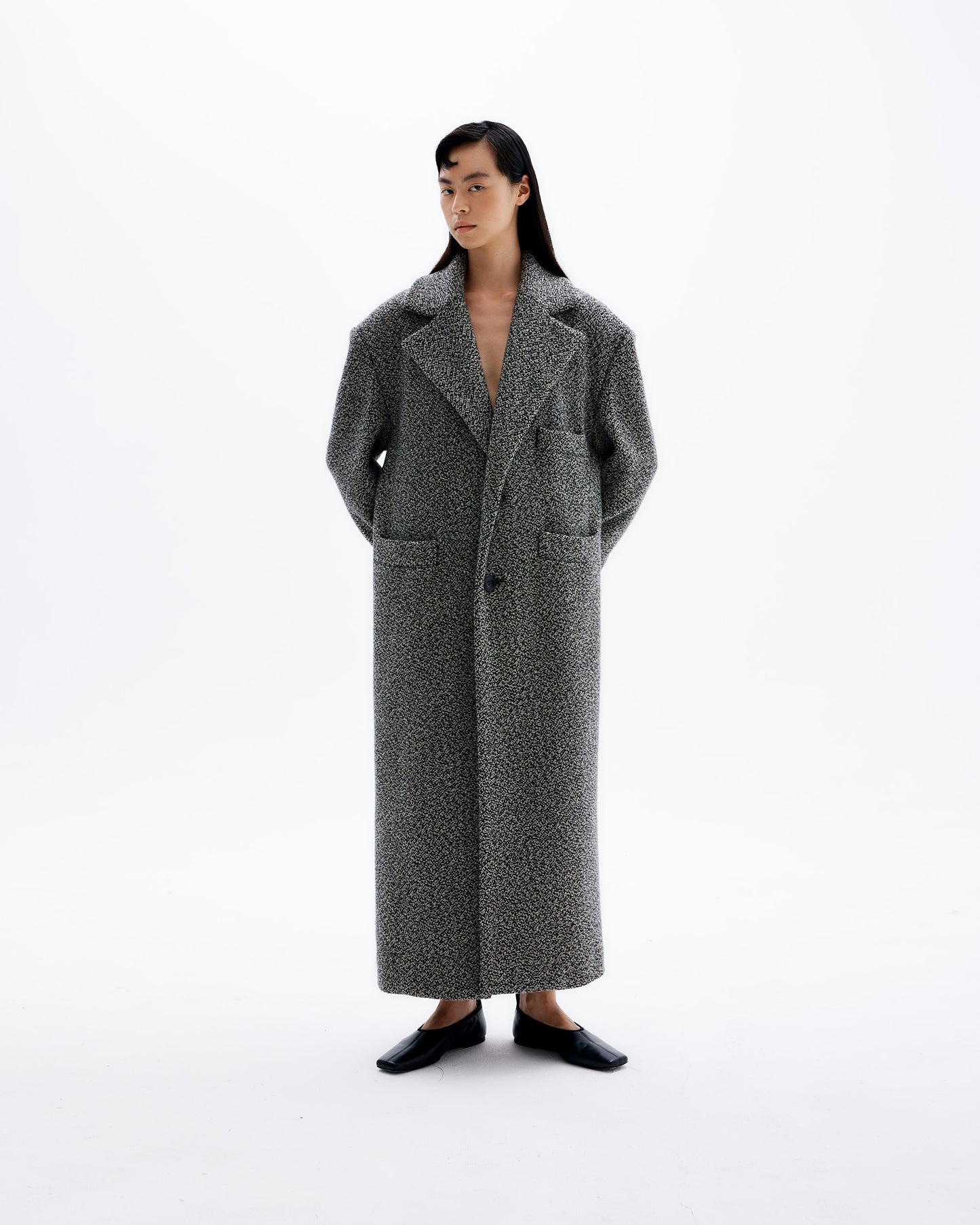 Cara wearing classic, oversized unisex coat with padded shoulders made of finest Italian wool. 