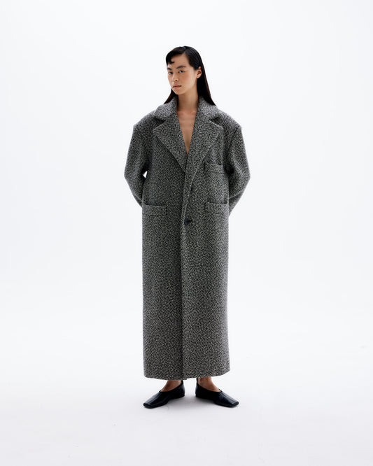 Cara wearing classic, oversized unisex coat with padded shoulders made of finest Italian wool. 