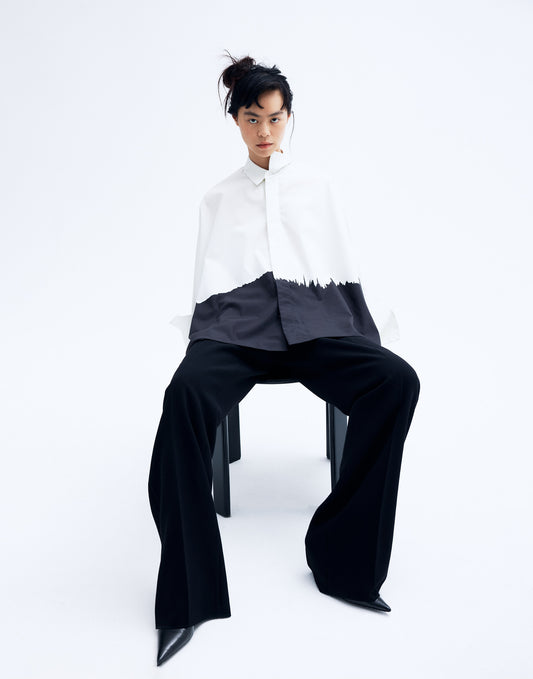 Model wearing a black and white printed cotton kimono shirt with wide sleeves and a relaxed silhouette, featuring an abstract brushstroke design.