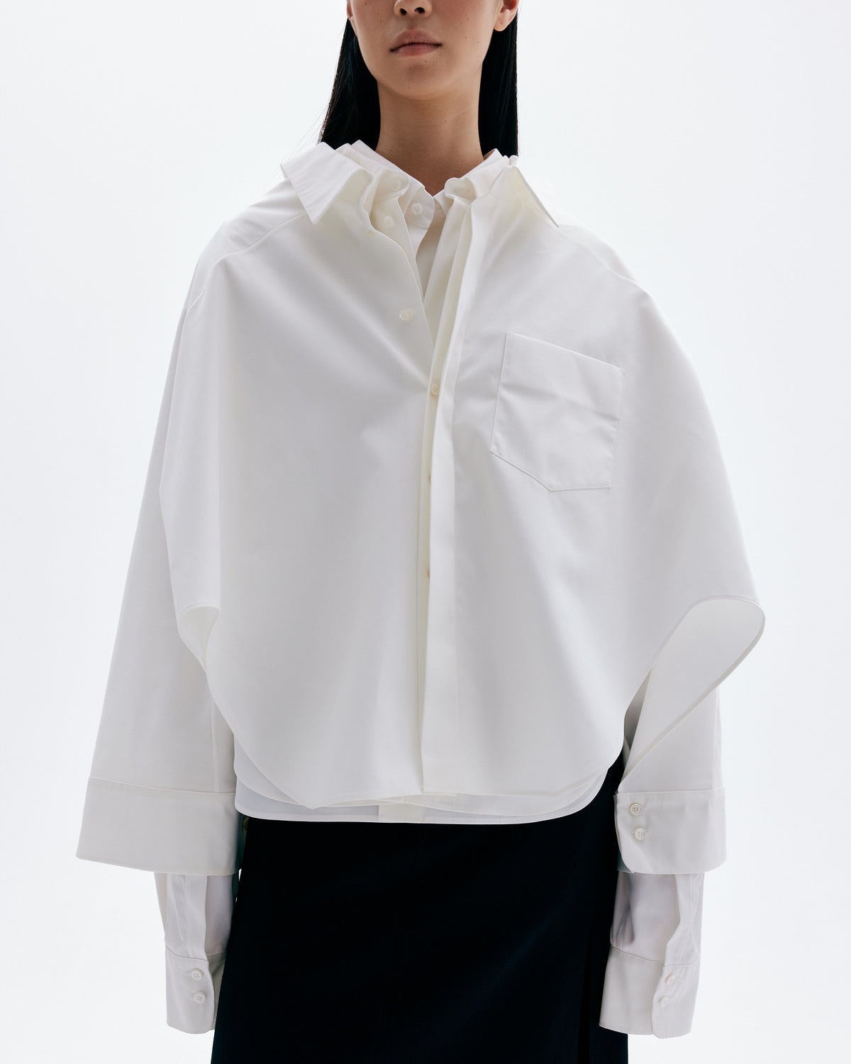 Model wearing layered sculptural cotton shirts