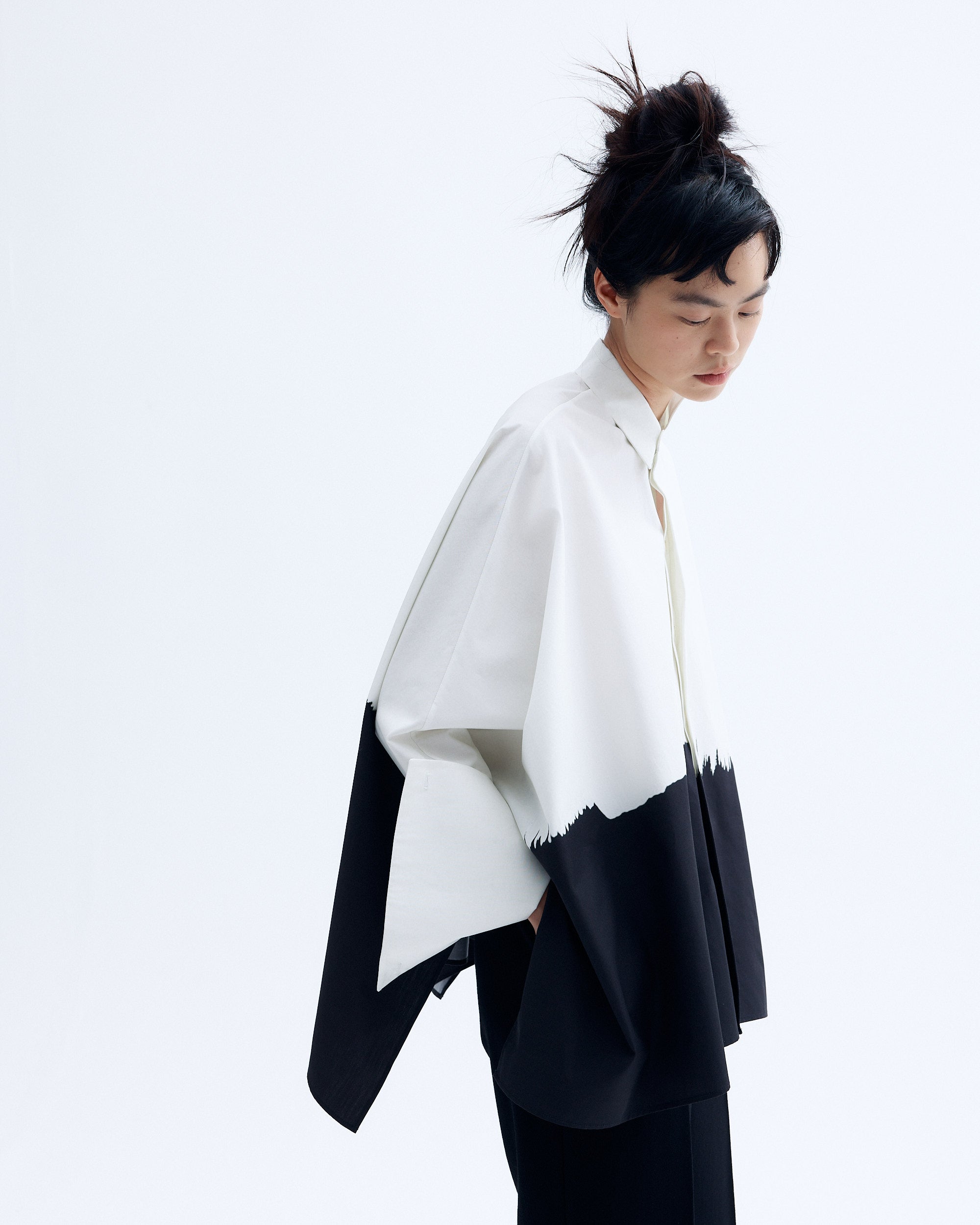 Model wearing a black and white printed cotton kimono shirt with wide sleeves and a relaxed silhouette, featuring an abstract brushstroke design.