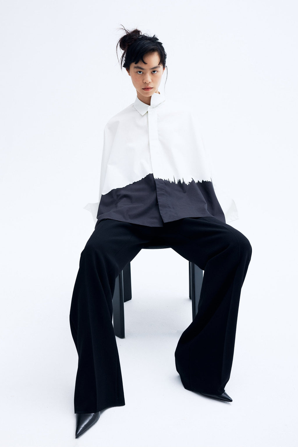 Model wearing architecture inspired cotton kimono shirt with abstract brushstroke print and sculptural wide sleeves.