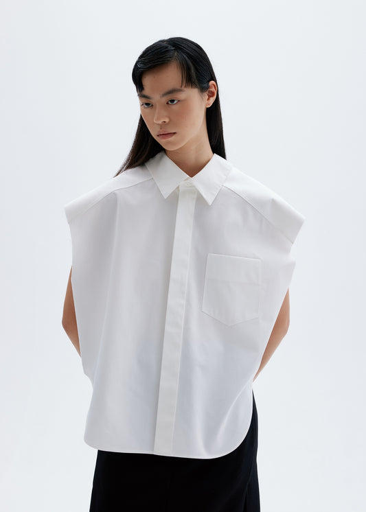 Model in structured sleeveless white cotton shirt with sharp collar and chest pocket