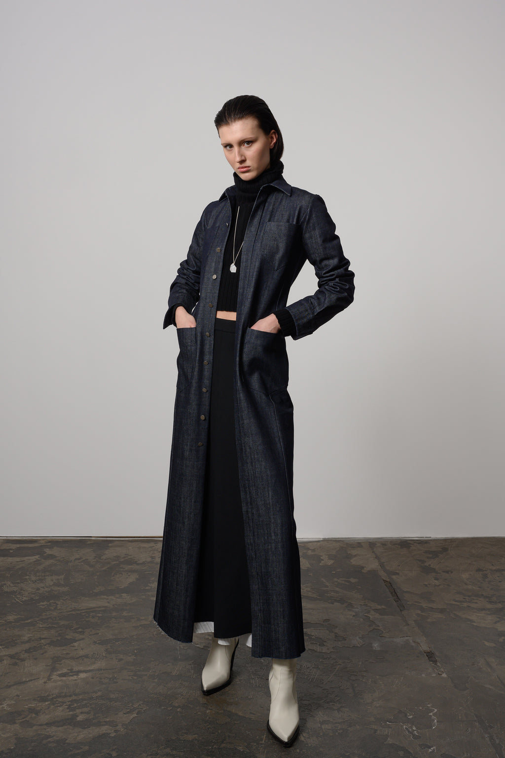 Model Zoe wearing full-length denim maxi shirt dress with pointed collar, button placket, and side pockets for a stylish yet functional outfit.