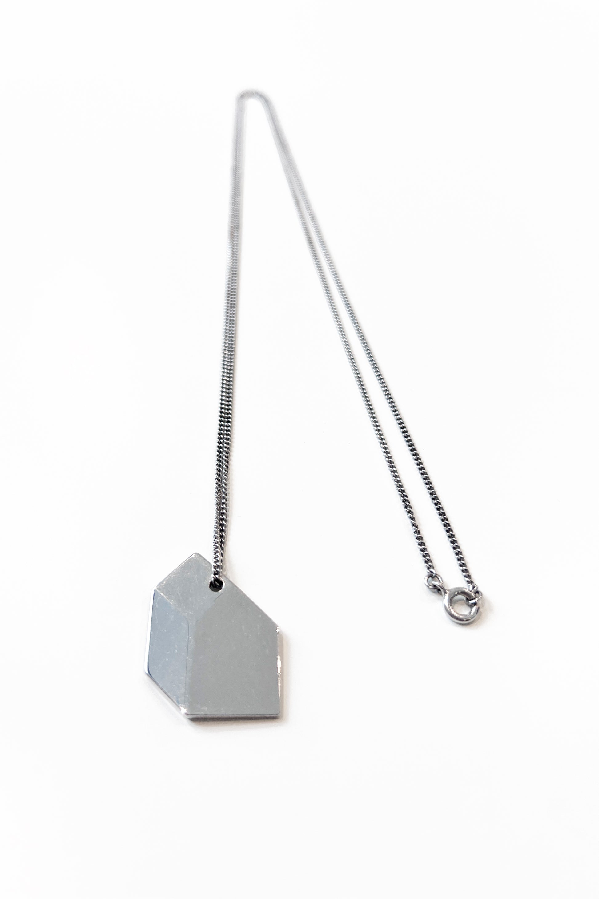 Sculptural necklace crafted from solid 925 sterling silver with geometric pendant.