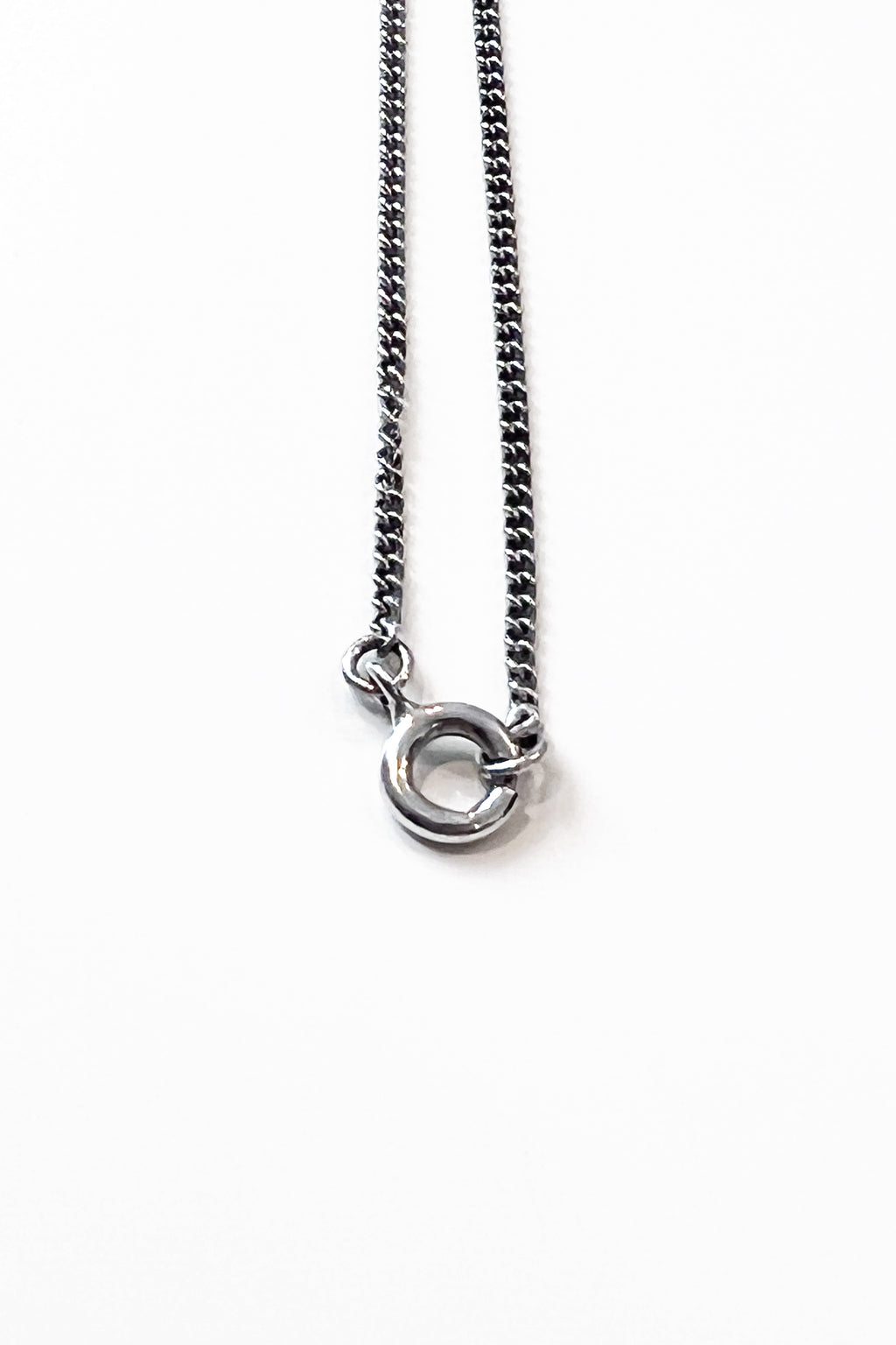 Close-up of sculptural necklace crafted from solid 925 sterling silver with geometric pendant.
