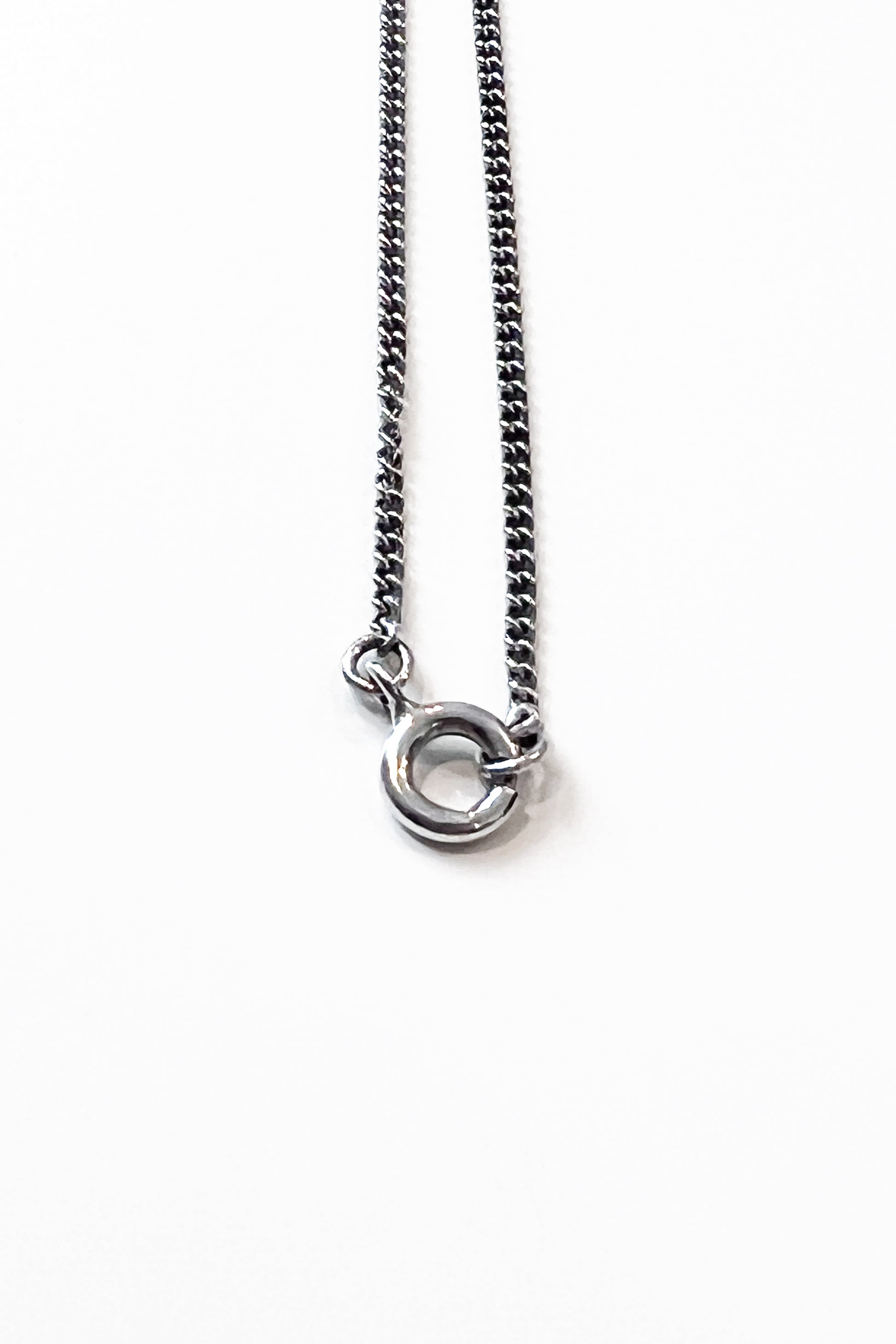 Close-up of sculptural necklace crafted from solid 925 sterling silver with geometric pendant.