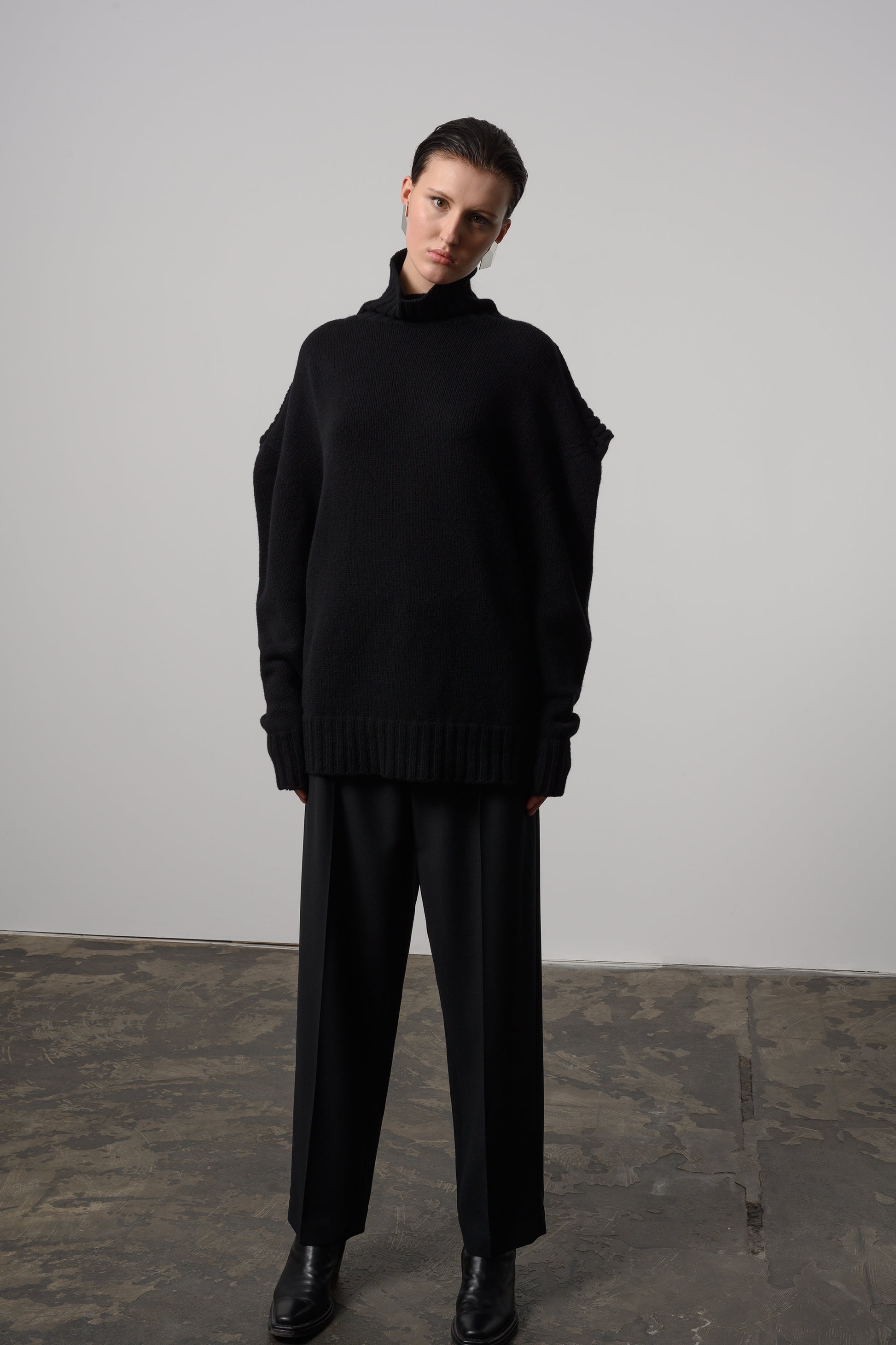 Elegant black chunky loop turtleneck sweater with a unique loop detail and snug ribbed cuffs for a sophisticated, cozy winter look
