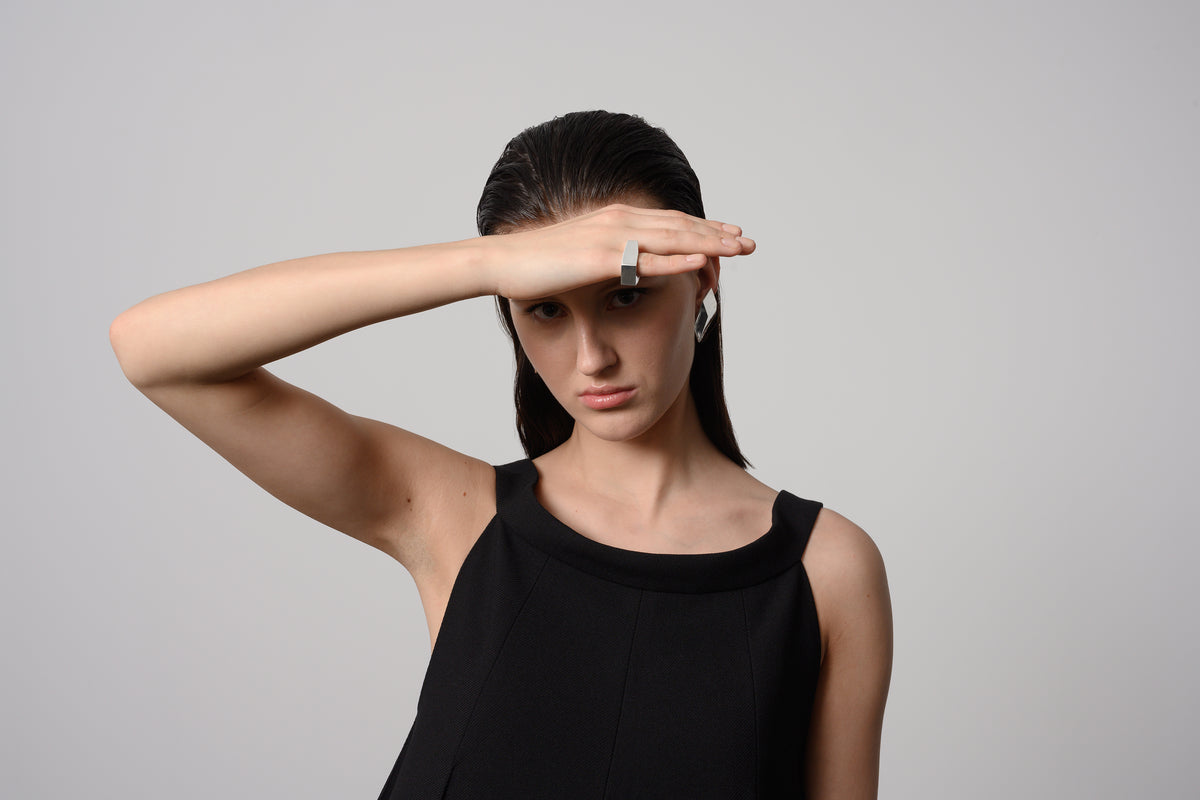 Model wearing architectural sterling silver ring with sculptural geometric silhouette and minimalist contemporary form.