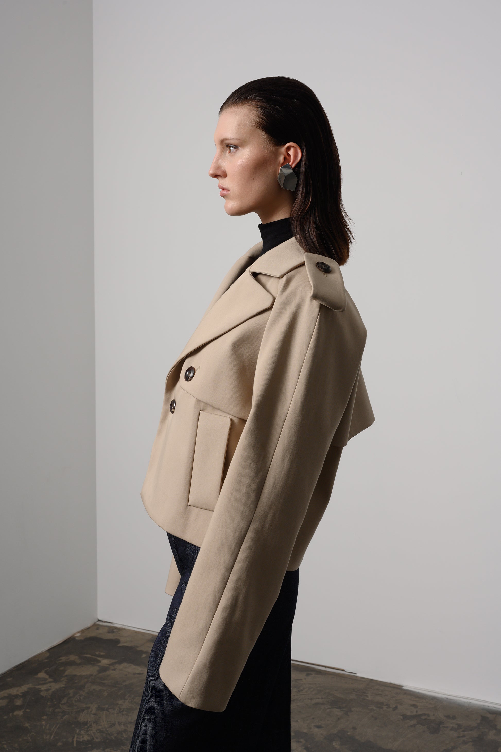 Chic  cropped trench jacket with modern epaulette details, a double-breasted front, and long sleeves, blending classic design with a contemporary cropped cut